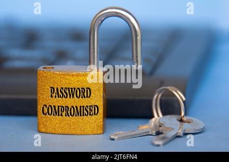 Password compromised text engraved on padlock with blurred keyboard background. Password security concept. Stock Photo