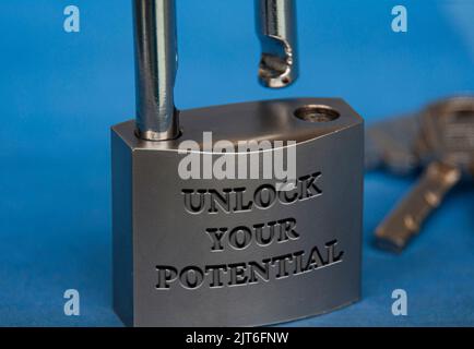 Unlock your potential text engraved on padlock with dark blue background. Motivational concept. Stock Photo