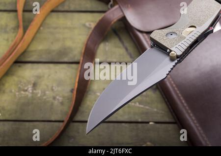 The blade of the knife is pierced in the air. Knife over the table. Knife over the bag. View from above. Stock Photo