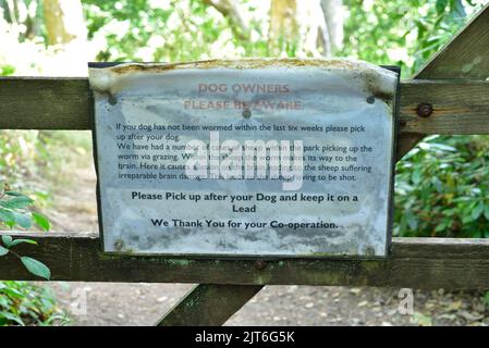 Notice on a gate on the south west coast path between Plymouth and Kingsand, requesting dog owners to pick up after unwormed dogs. Stock Photo