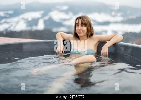 Woman bathing in hot tub at mountains Stock Photo