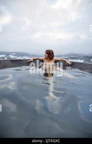 Woman bathing in hot tub at mountains Stock Photo