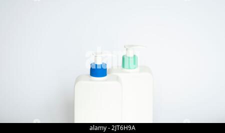 Two white plastic bottles with black dispenser, isolated on white background Stock Photo