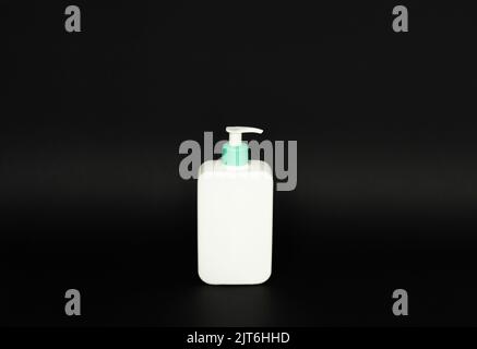 White unbranded plastic dispenser pump bottle on black background. Cosmetic package mockup, liquid soap flacon, hand sanitizer without label, shampoo Stock Photo