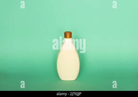 Beige blank plastic bottles isolated on green background. Stock Photo