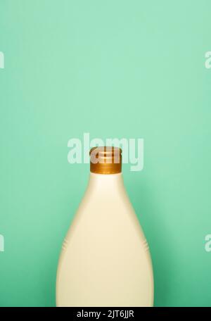 Beige blank plastic bottles isolated on green background. Stock Photo