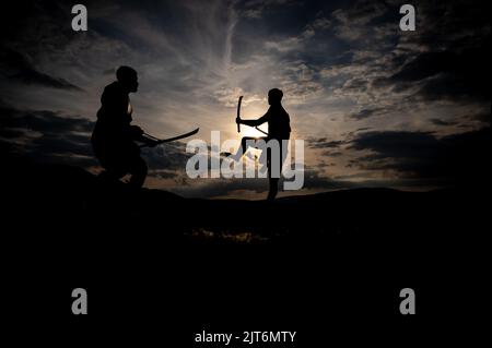 Martial arts sword fighting silhouettes at sunset Stock Photo