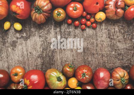 Untreated organic tomatoes on a dark table, top view with copy space Stock Photo