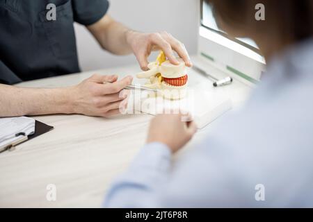 Young woman in consultation with a physical therapist at medical office Stock Photo