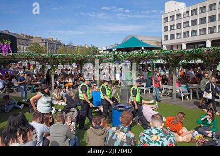 Edinburgh, UK. 28th Aug, 2022. Edfringe penultimate day, Edinburgh, Scotland, UK. Still busy around the High Street and Mound on the second last day of the Edinburgh Festival Fringe. Temperature 19 degrees centigrade. Pictured: Three police officers pass through Bristo Square Underbelly. Credit: ArchWhite/alamy live news. Credit: Arch White/Alamy Live News Stock Photo