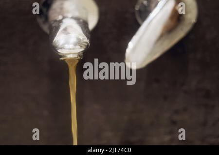 Rusty dirty water flows in a home sink from a faucet Stock Photo