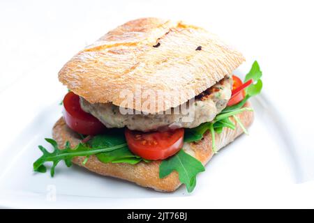 homemade turkey burger with cherry tomatoes and arugula in ciabatta Stock Photo