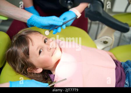 Tranquil female child undergoing routine examination in dental clinic Stock Photo