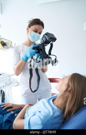 Pediatric dentist taking photos of patient teeth Stock Photo