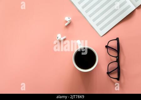 Notebook, glasses and coffee on a pink background, flat lay. Stock Photo