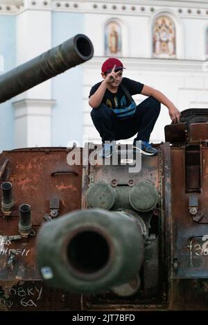 August 28, 2022, Kiev/Kiiv city, Kiev/Kiiv city, Ukraine: On the esplanade of the Ministry of Foreign Affairs of Ukraine, a child makes the symbol of victory over a Russian tank destroyed on the outskirts of Kiev at the beginning of the Russian invasion (Credit Image: © Eric Renom/ZUMA Press Wire) Credit: ZUMA Press, Inc./Alamy Live News Stock Photo