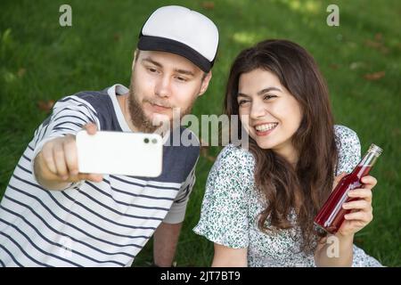 A young man and woman take a selfie at a picnic, outdoor recreation. Stock Photo