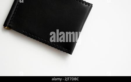 Black money clip handmade from genuine leather on white surface. Stock Photo