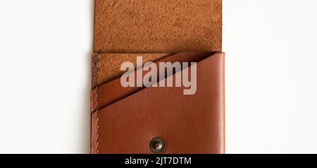 Opened empty orange genuine leather card holder on a white surface. Stock Photo