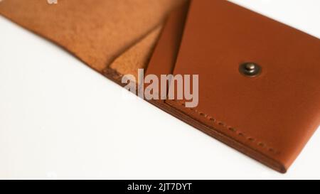 Opened empty orange genuine leather card holder on a white surface. Stock Photo