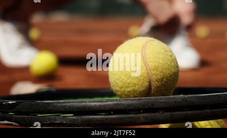 Yellow tennis ball on a tennis racket Stock Photo