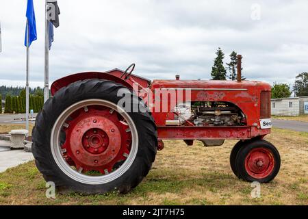 Sequim, WA USA - 07-18-2022: Red Farm Tractor in front of Sequim Museum and Arts Building Stock Photo