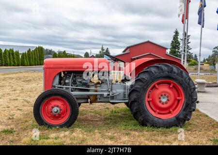 Sequim, WA USA - 07-18-2022: Red Farm Tractor in front of Sequim Museum and Arts Building Stock Photo