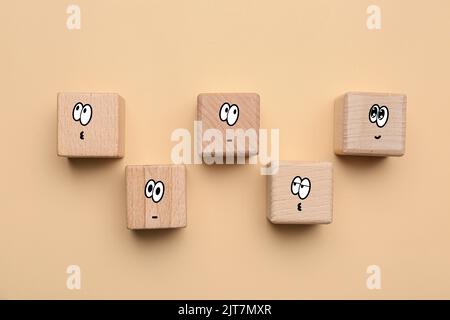 Wooden cubes with different drawn emoticons on beige background Stock Photo