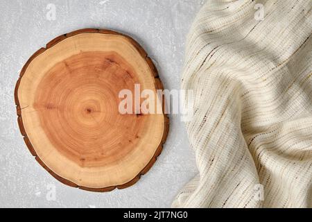 Cutting board and coasters on a gray concrete table with a kitchen towel. Food display template Stock Photo