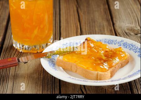 Toast with orange marmalade on wooden background closeup macro horizontal Stock Photo