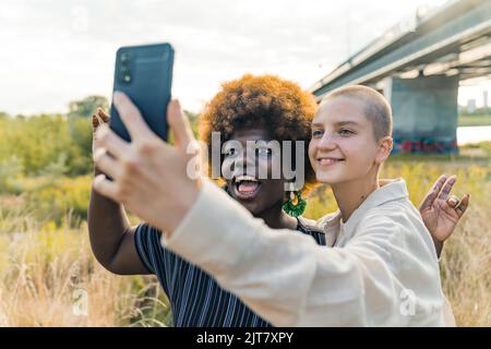 multiracial women taking a funny photo together, medium closeup outdoors. High quality photo Stock Photo
