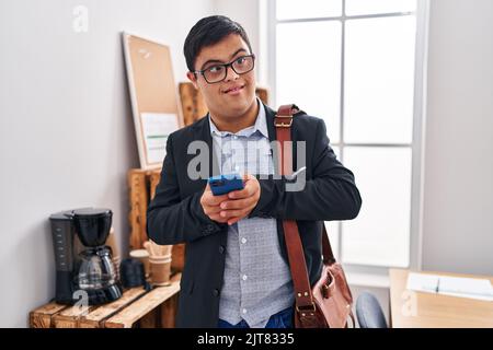Down syndrome man business worker using smartphone at office Stock Photo
