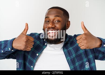 Portrait of happy afroamerican handsome bearded man laughing and showing thumb up gesture. Stock Photo