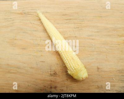 raw baby corn, raw baby corn isolated on wooden cutting board Stock Photo