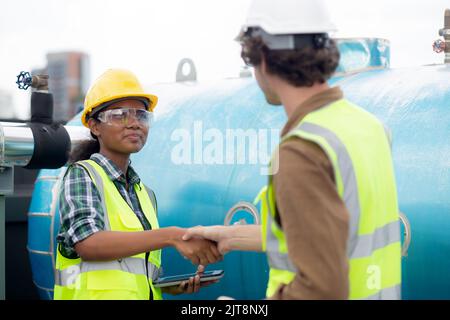 Young woman and man engineer doing agreement and handshake in the factory, mechanic and partner inspector plumber valve and deal for success together, Stock Photo