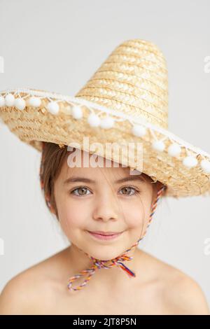 Do you like my fancy hat. Studio portrait of a cute little girl wearing a funny hat. Stock Photo