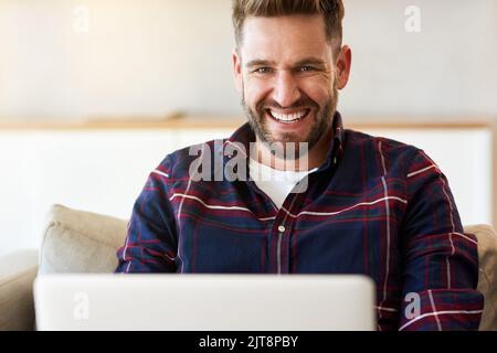Leisurely browsing all afternoon long. a relaxed young man using a laptop on the sofa at home. Stock Photo