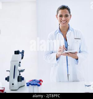 Technology is a vital tool for every researcher. Portrait of a young female scientist working in a lab. Stock Photo
