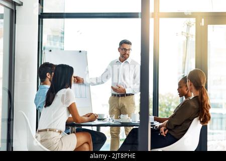 Business, business and nothing but the business. a businessman giving a presentation to his colleagues in a modern office. Stock Photo