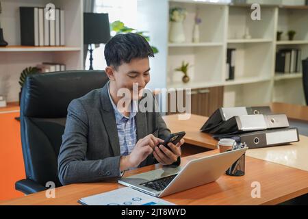 businessman manager  portrait using smartphone smiling happy Man on smart phone young business man caucasian communication cellphone contact typing mo Stock Photo