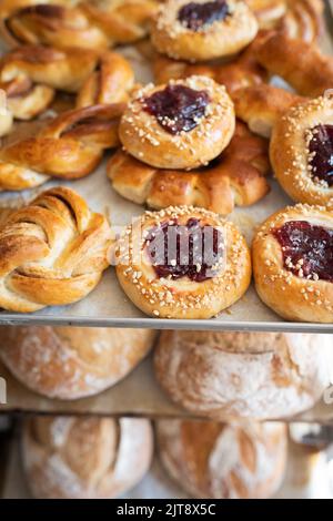 The bakery's assortment meter is on the counter. Rich pastries with fruit filling, puff pastry, artisan bread. Front view. Stock Photo