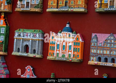 Rows of fridge magnet souvenirs from Gdansk displayed on stillage. Model houses magnets on display in Gdansk Poland travel destination concept in city market square Stock Photo