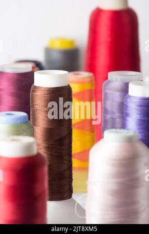 close-up of spool of sewing threads used in fabric and textile industry, different colors, soft-focus background Stock Photo