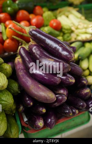 Long Purple Eggplant or Eggplant piled on the traditional market with vegetables Stock Photo