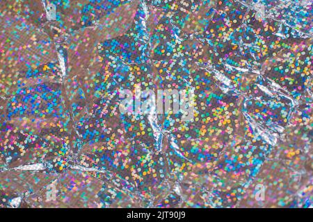 Festive Sparkle glitter background in bright color bokeh. Crumpled wrapping paper. Creased shiny holographic metal foil sheet Stock Photo