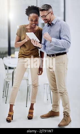 Youll be surprised by what you can achieve with technology. a businessman showing something to his colleague on his tablet in the office. Stock Photo