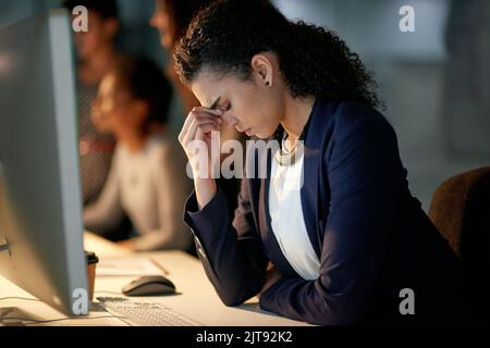 How am I going to get through all of this...a stressed out businesswoman working late in an office. Stock Photo