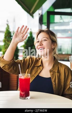 smiling asian girl waving to someone Stock Photo