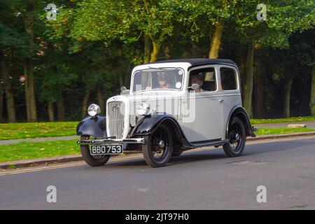 1938 Grey White AUSTIN 7 SEVEN 885cc petrol pre-war classic British sedan; arriving at the annual Stanley Park Classic Car Show in the Italian Gardens. Stanley Park classics yesteryear Motor Show Hosted By Blackpool Vintage Vehicle Preservation Group, UK. Stock Photo