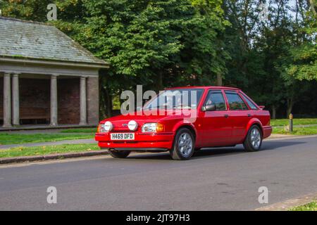 1990 90s nineties red Ford Escort Ghia 1392cc petrol 5-speed manual; arriving at the annual Stanley Park Classic Car Show in the Italian Gardens. Stanley Park classics yesteryear Motor Show Hosted By Blackpool Vintage Vehicle Preservation Group, UK. Stock Photo